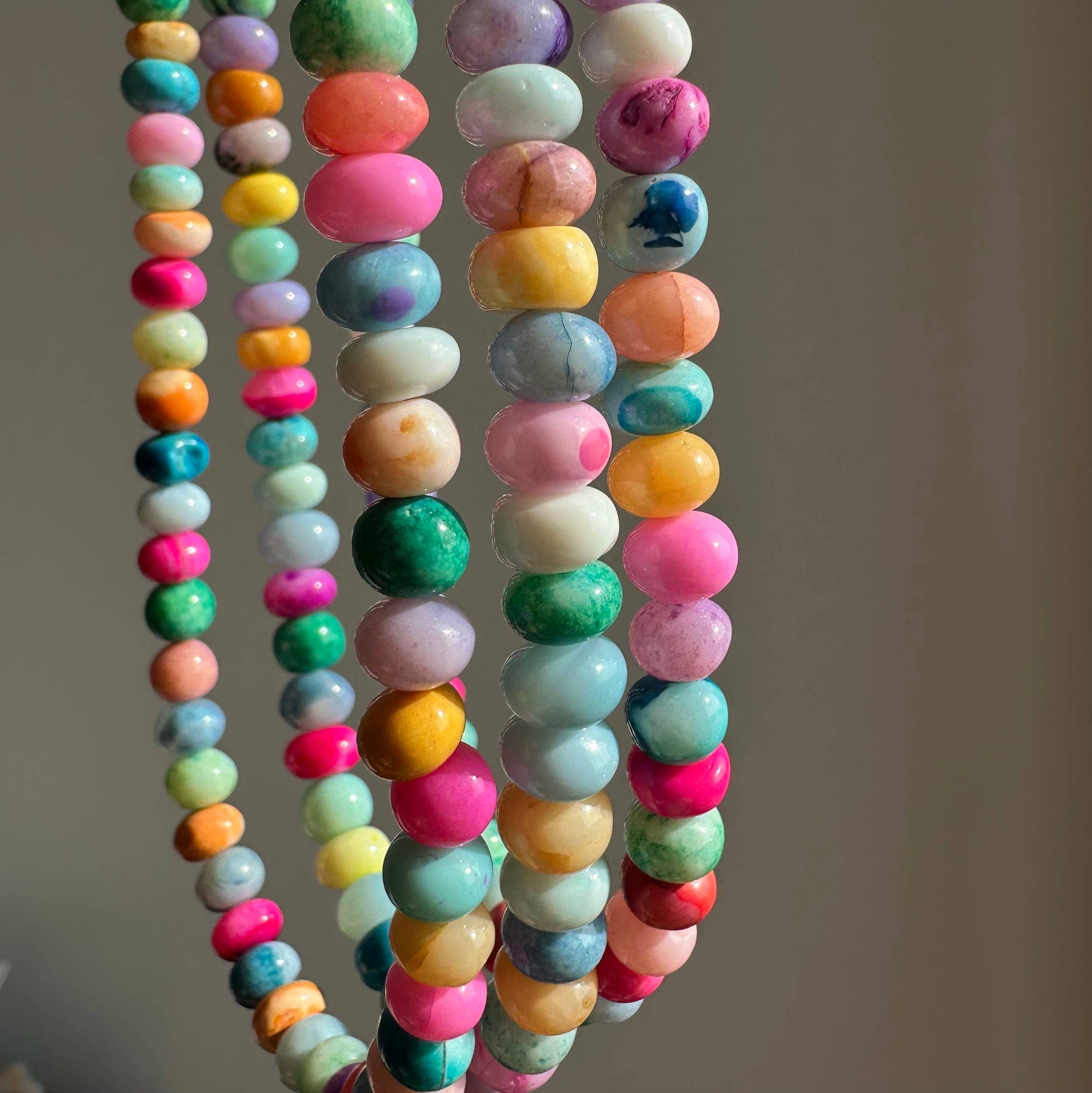 Colorful beaded necklaces on a neutral background