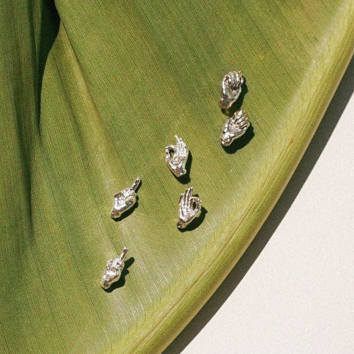 Silver jewelry pieces on a green leaf