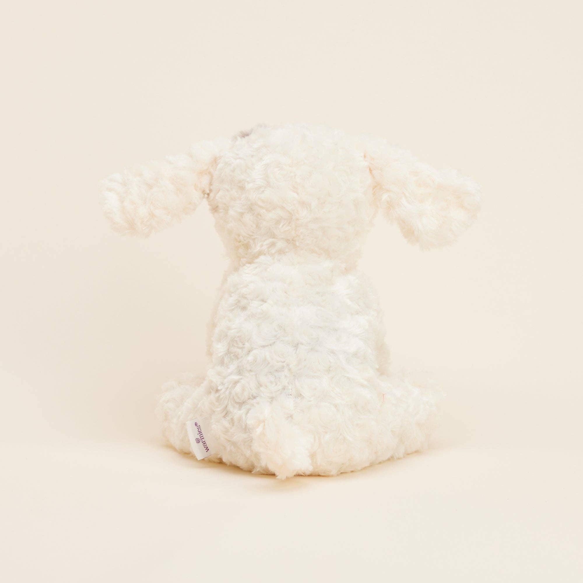 Close-up of a fluffy white pillow on a light beige background