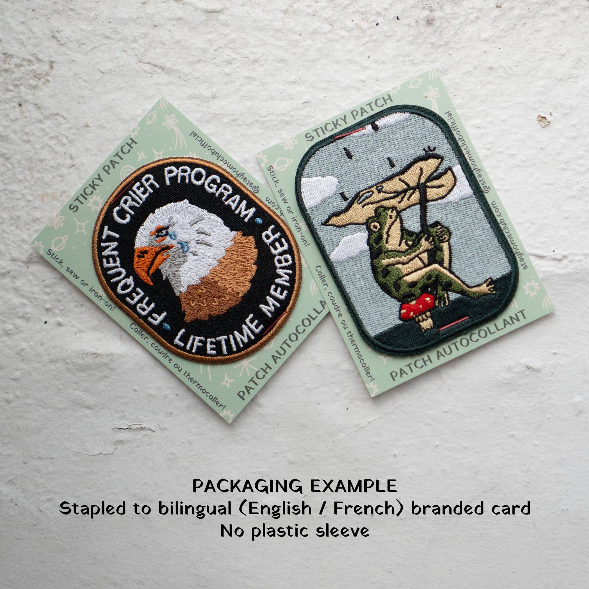 Two patches on cards with text and branding on a textured surface
