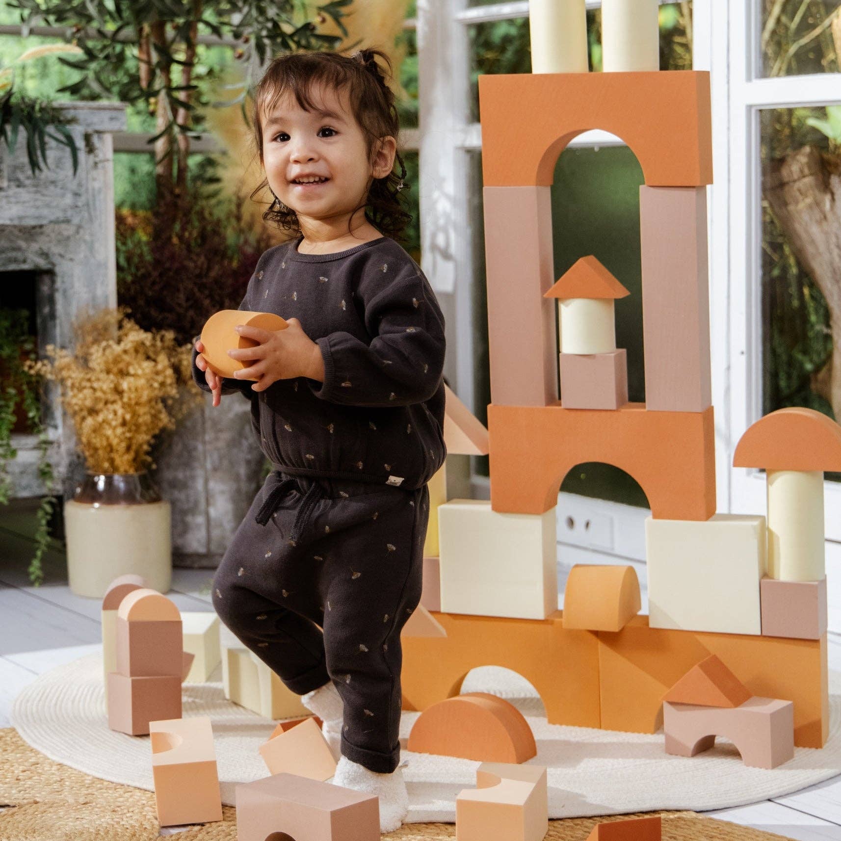 Child playing with wooden building blocks outdoors