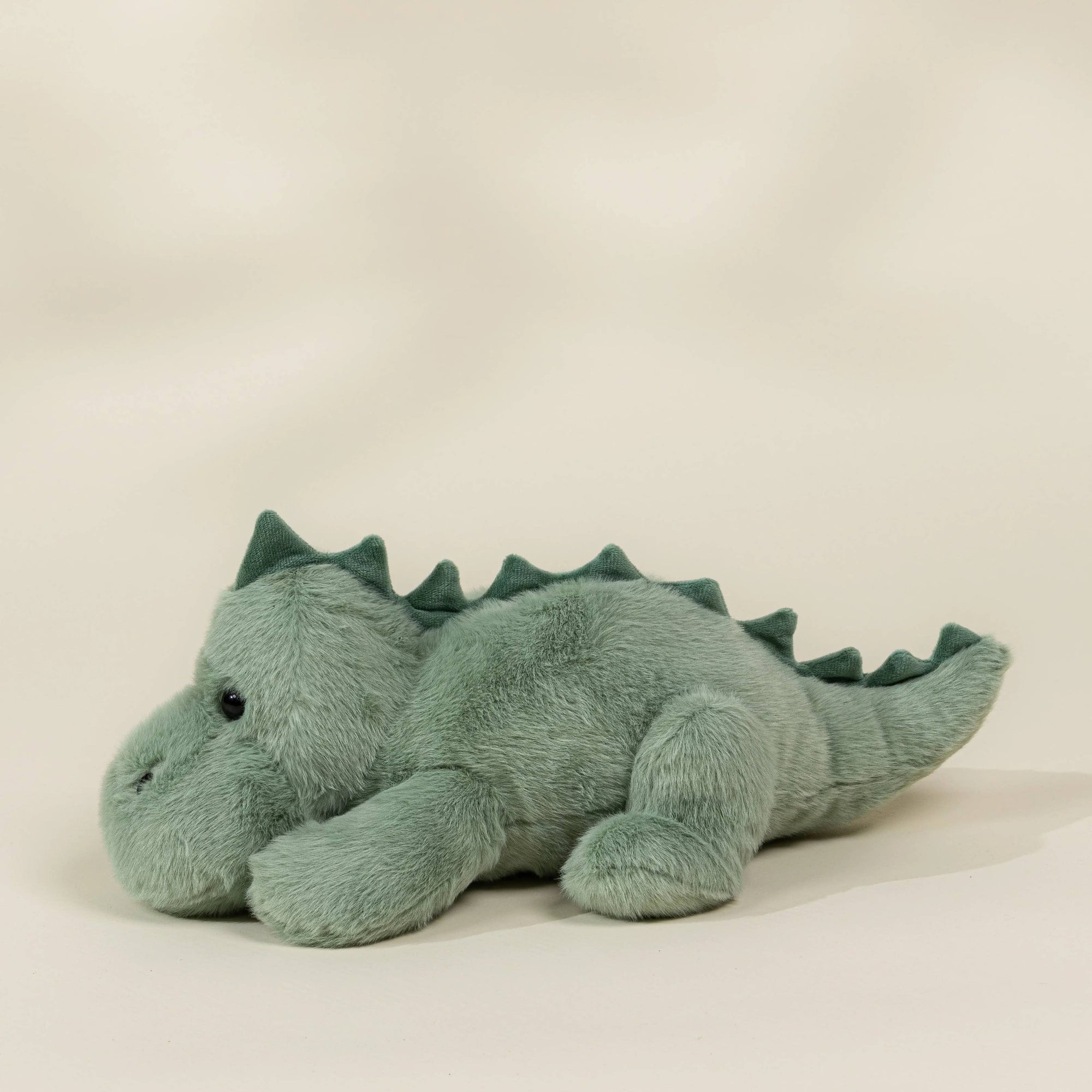 Plush dinosaur toy on a beige background