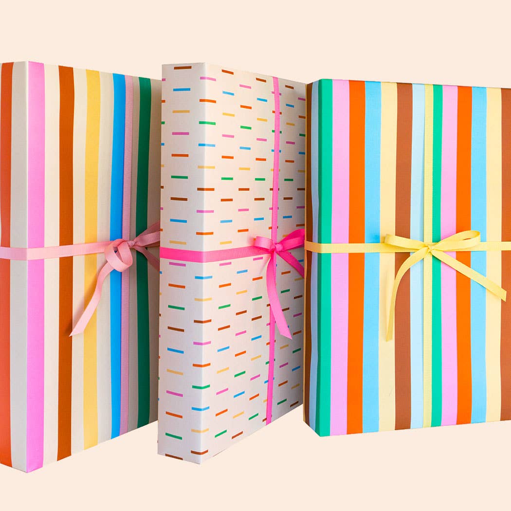 Three colorful gift boxes with ribbons on a beige background