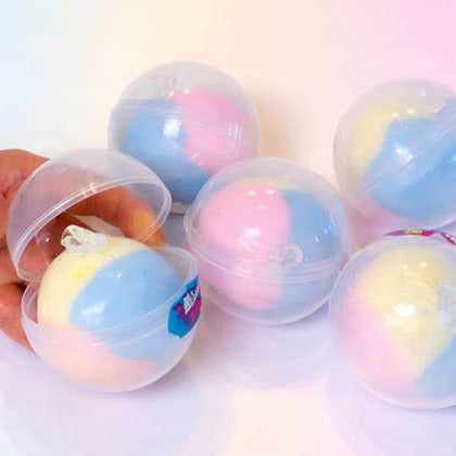 Colorful spherical candies in a clear plastic container on a white background