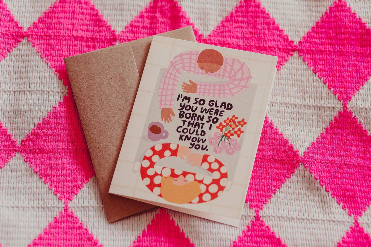 Greeting card with text and illustration on a pink and gray checkered background
