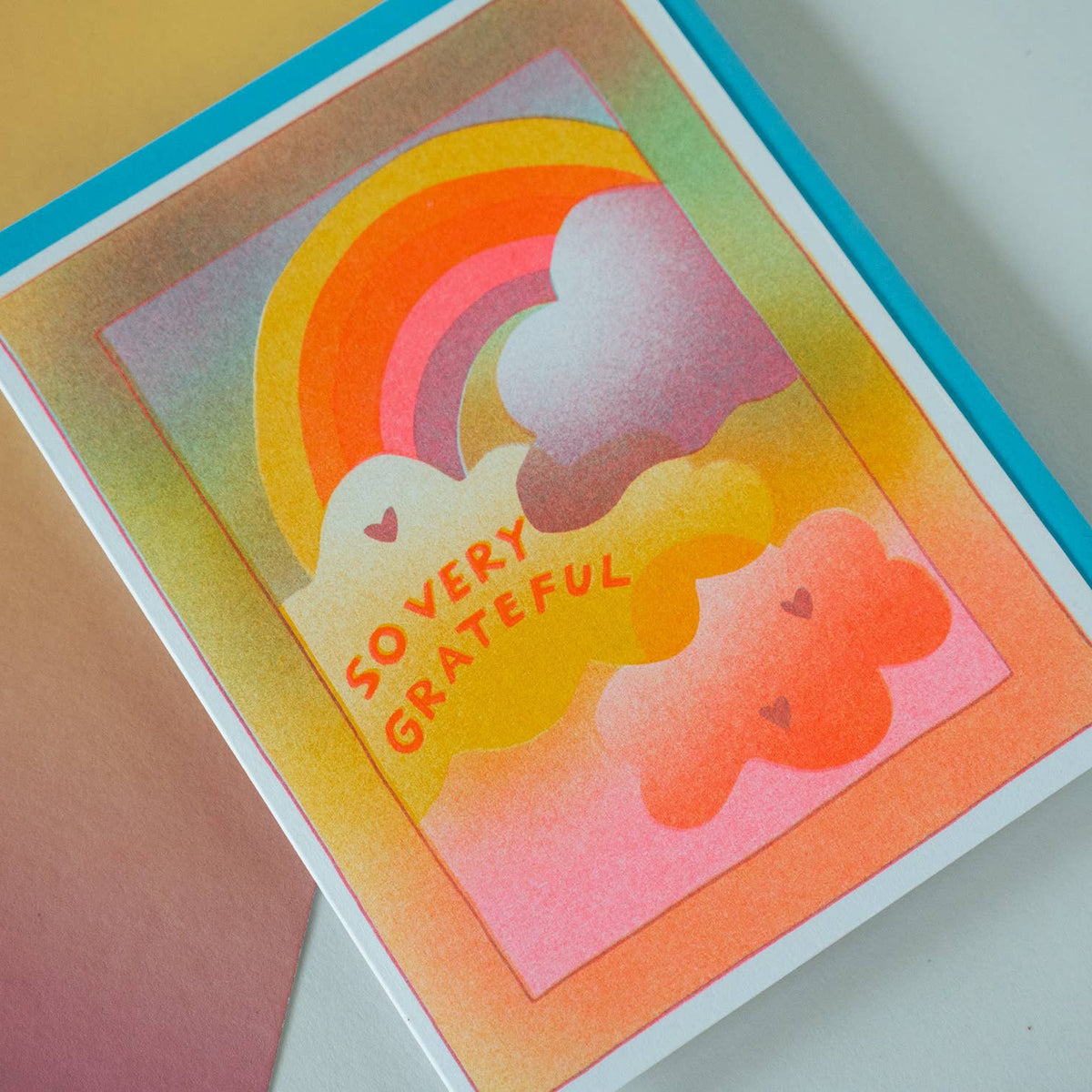 Colorful card with rainbow and cloud design and 'So Very Grateful' text on a gradient background.
