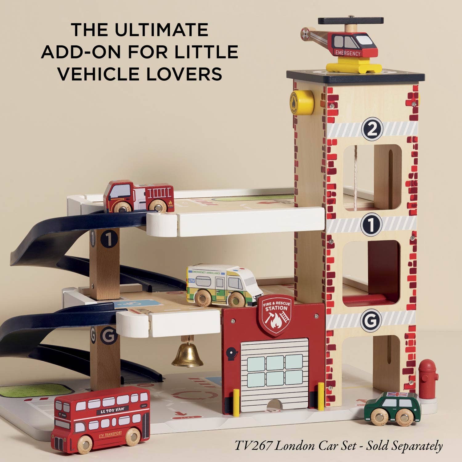 Wooden toy fire station with cars and helicopter on a beige background