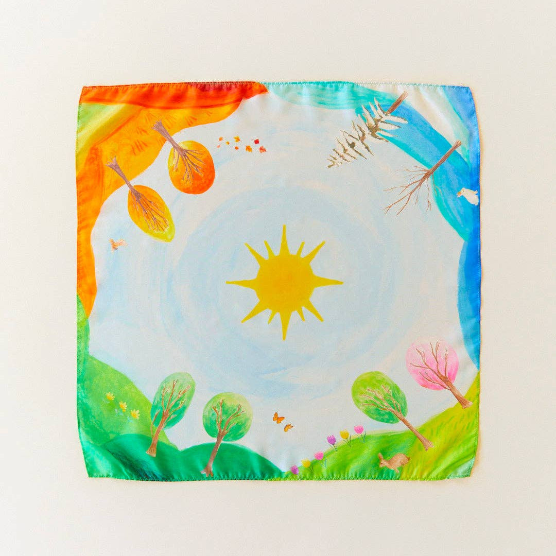 Colorful fabric square with a sun and nature-themed design on a white background