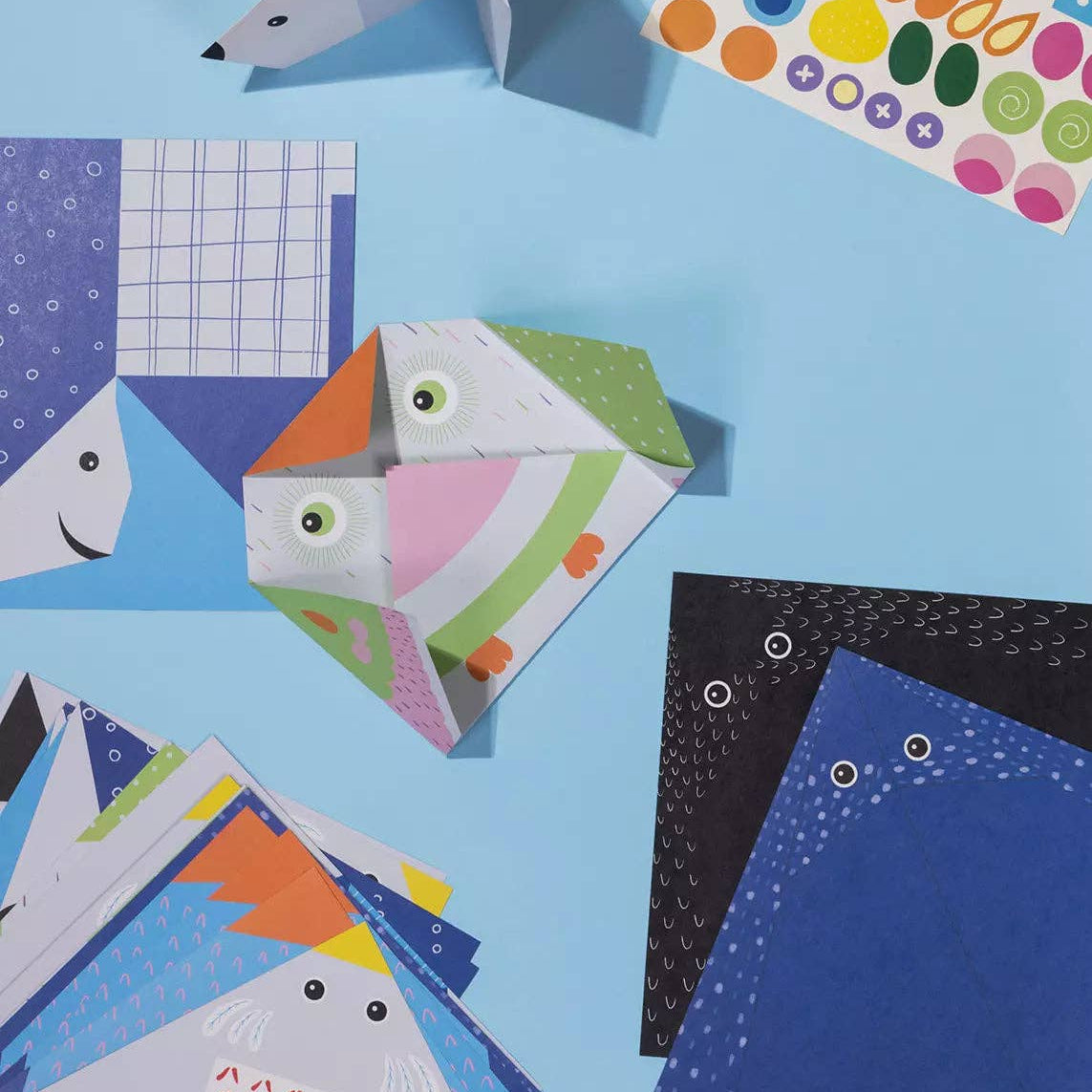 Colorful paper shark shapes on a blue background