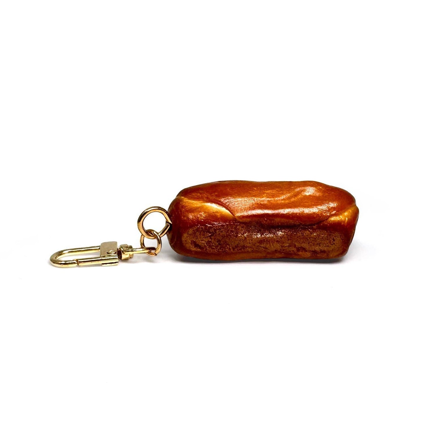 Brown bread-shaped keychain with gold clasp on a white background