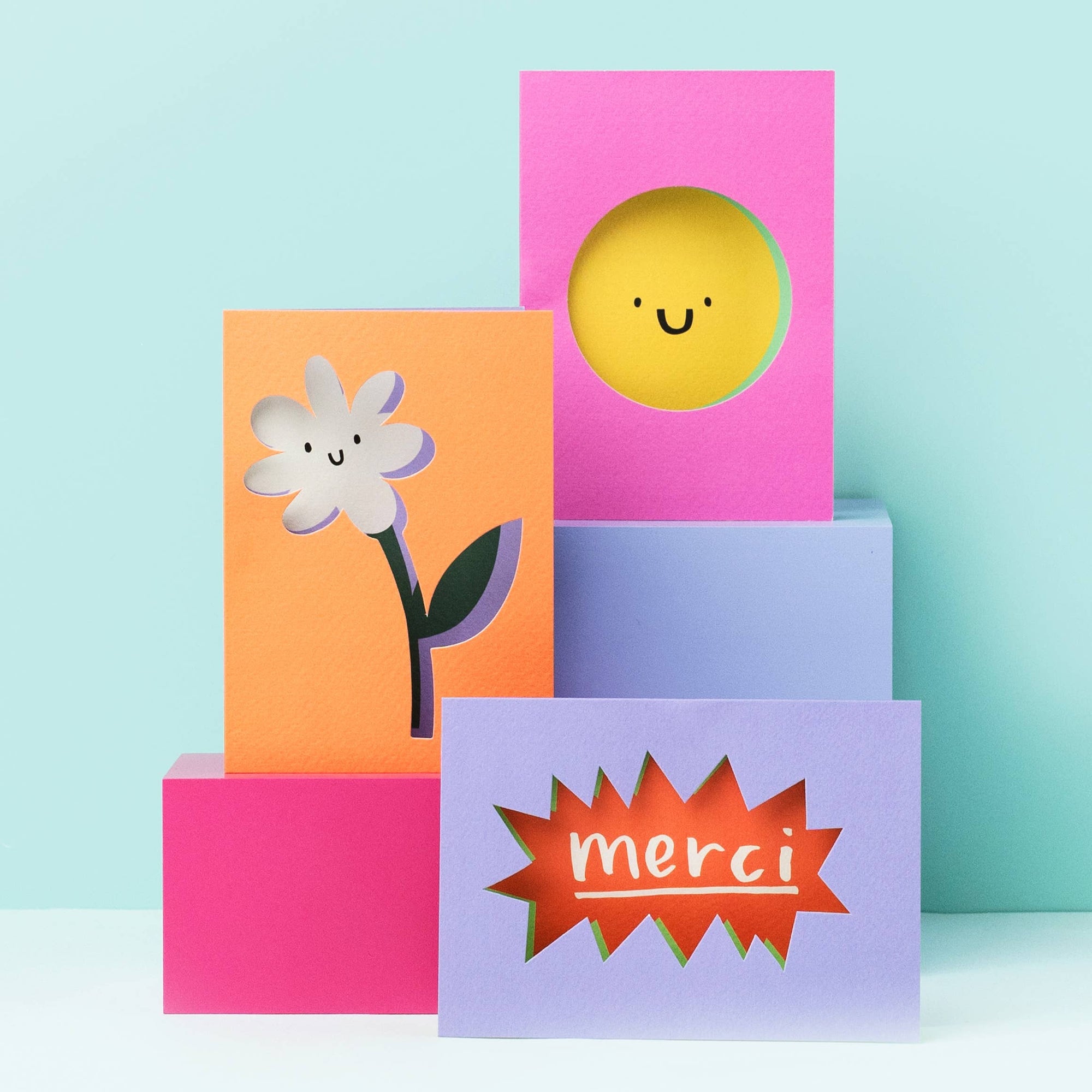 Colorful greeting cards with floral and sun designs on a light blue background