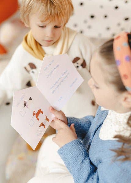 Two children looking at educational cards with pictures and text.