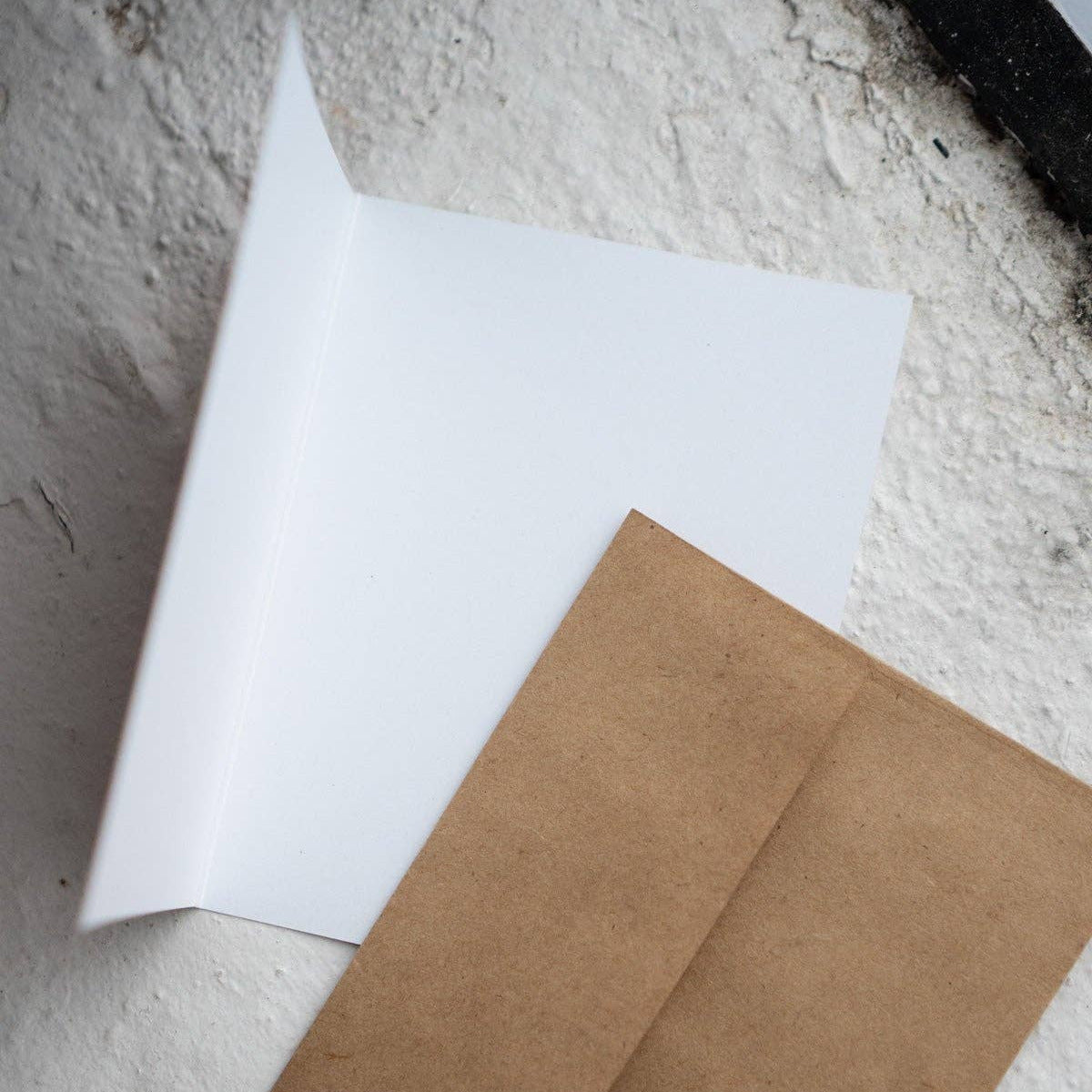 White sheet of paper and brown envelope on a textured surface