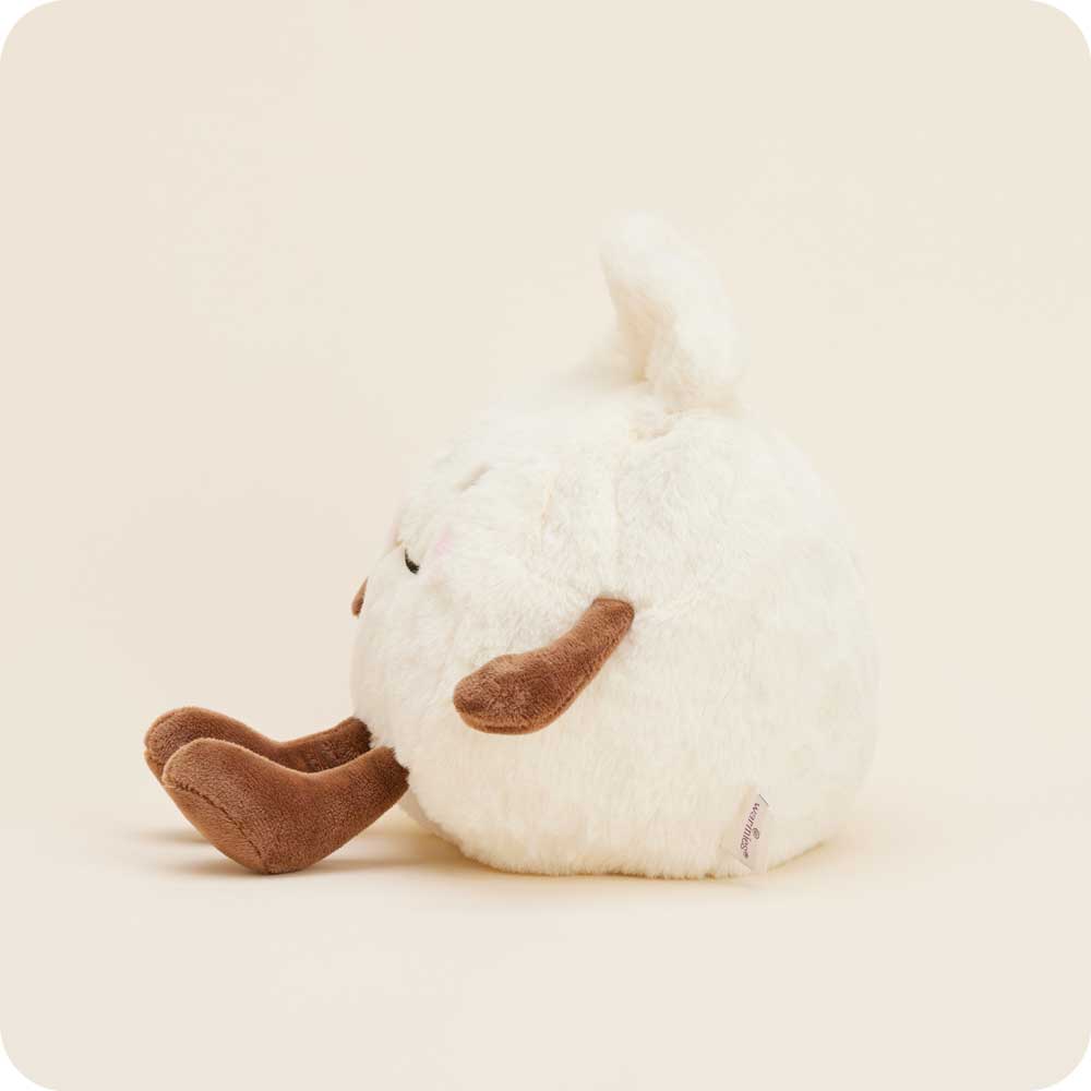White plush toy with brown feet on a beige background