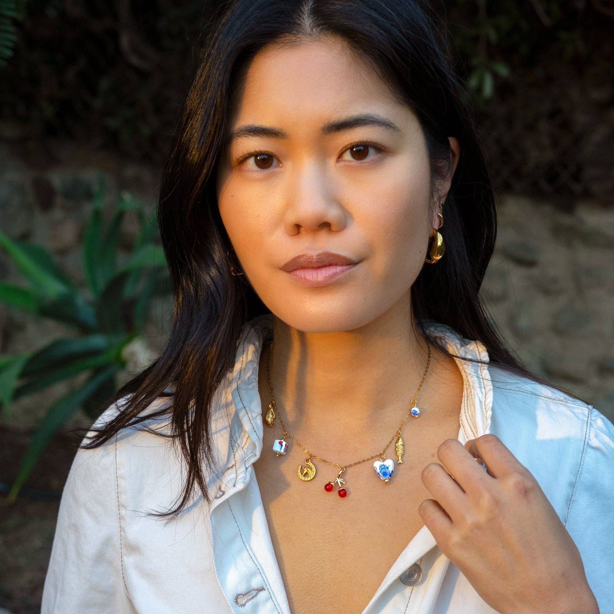 Woman wearing a white jacket with a necklace outdoors