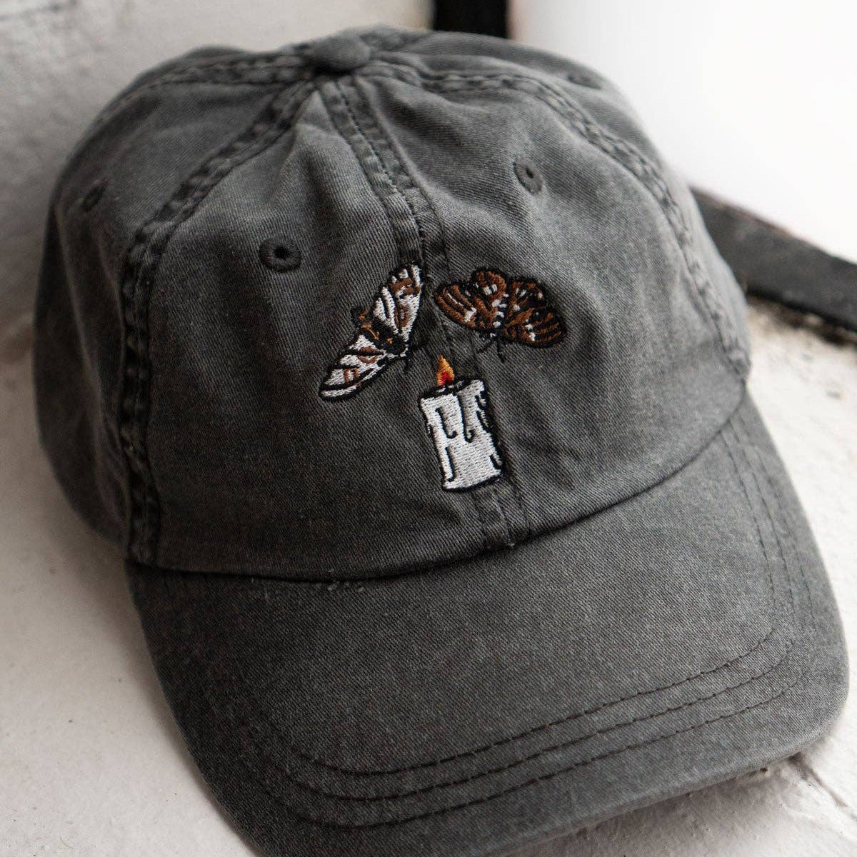 Gray cap with embroidered design on a white surface