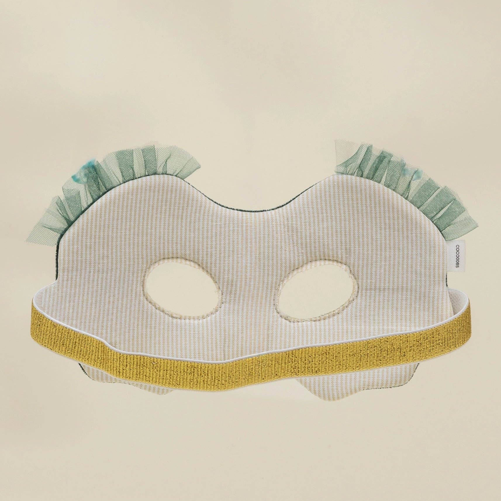 mask with green ruffles on a beige background