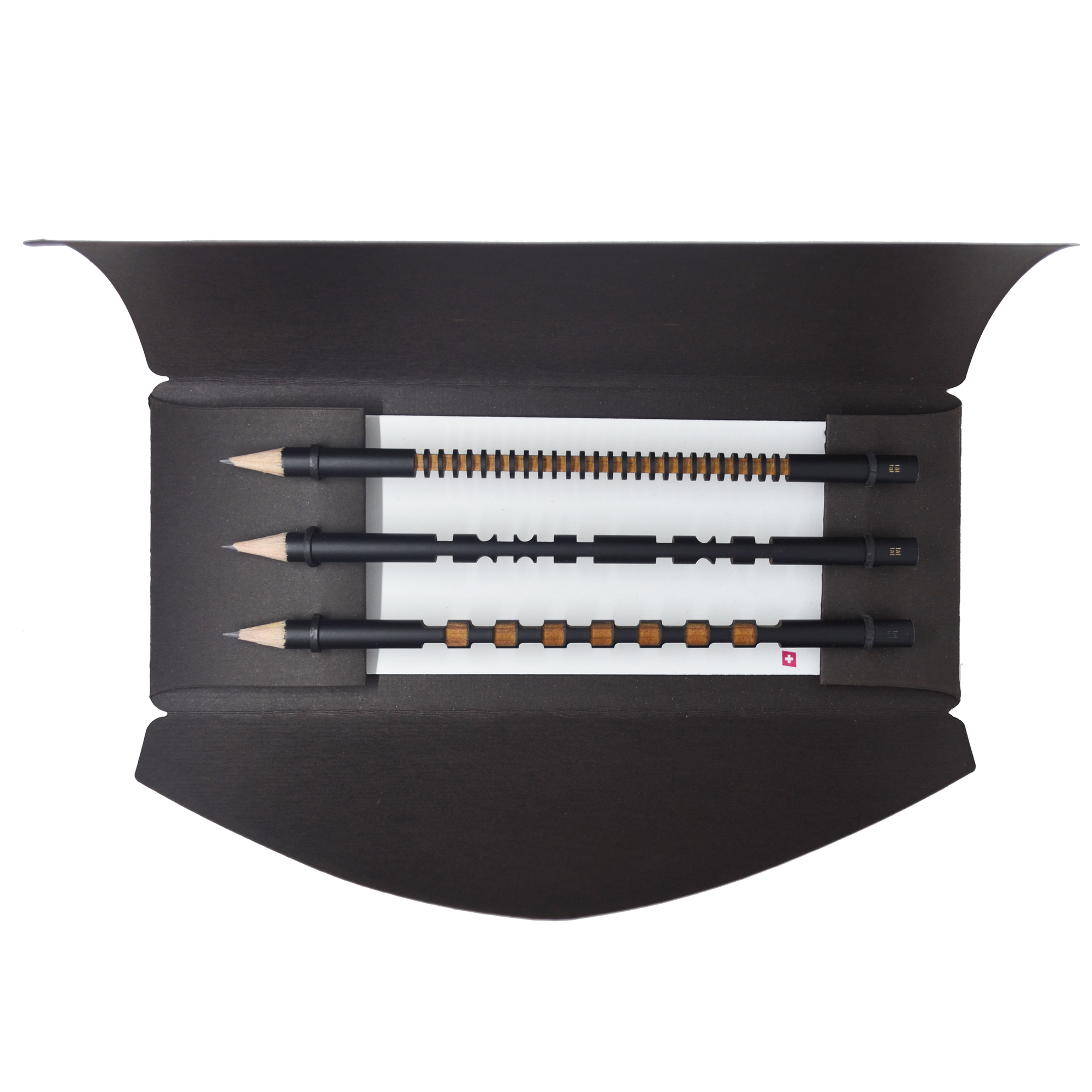 Set of black pencils with brown accents in a black holder on a white background