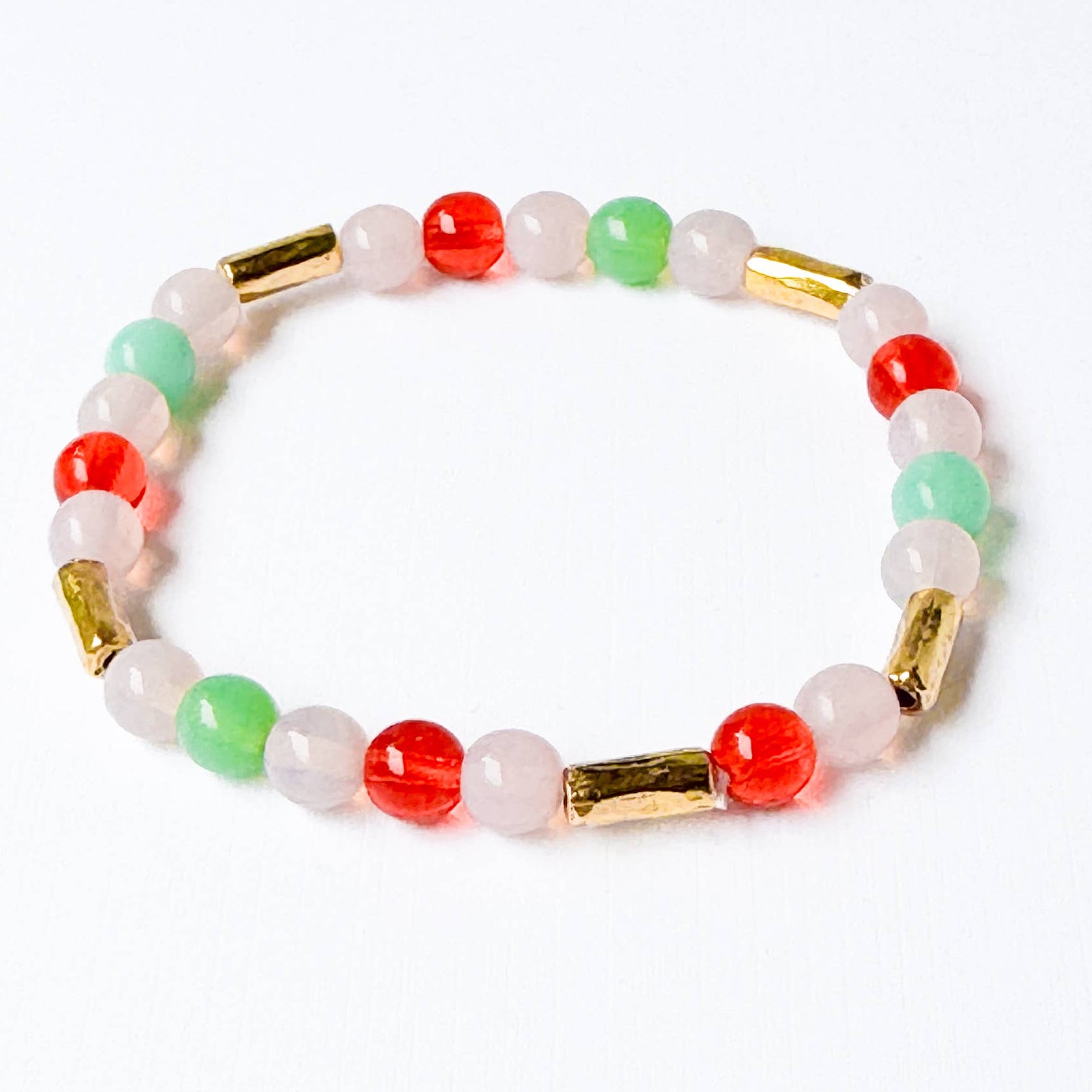 Multicolored beaded bracelet with gold accents on a white background