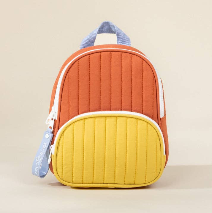 Colorful quilted backpack with orange top and yellow bottom on a beige background