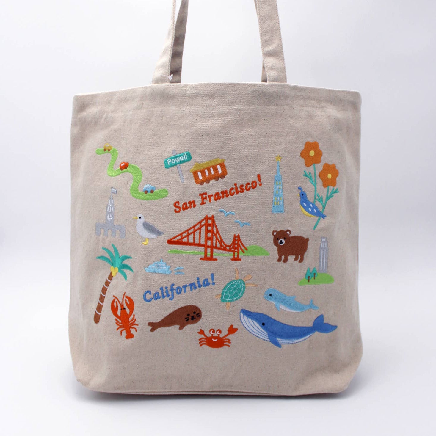 Beige tote bag with colorful illustrations of San Francisco on a white background