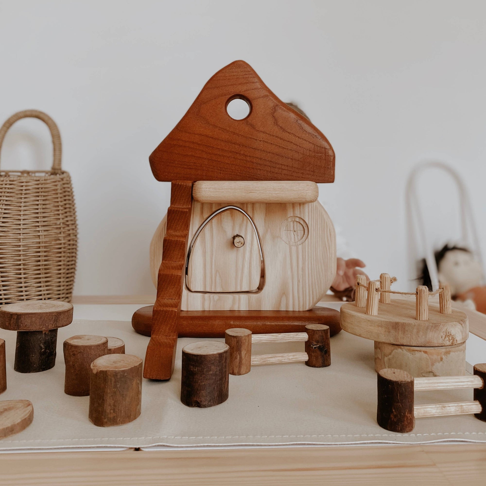 Wooden toy set with a house-like structure on a white surface.