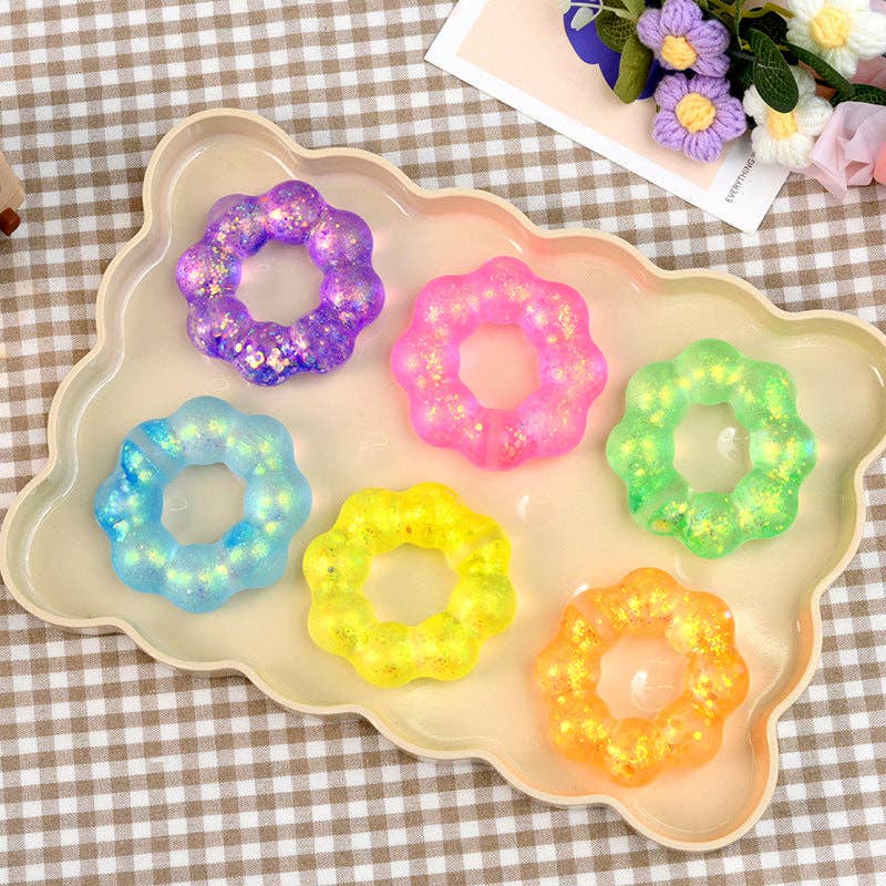 Colorful donut-shaped gelatin desserts on a decorative tray with a checkered tablecloth background.