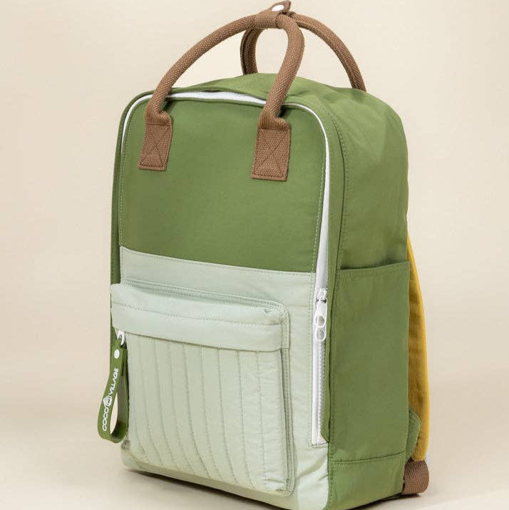 Green and mint backpack with brown handles on a beige background