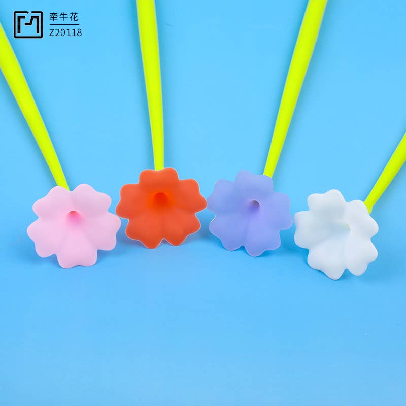 Colorful flower-shaped pen tips on green straws against a blue background