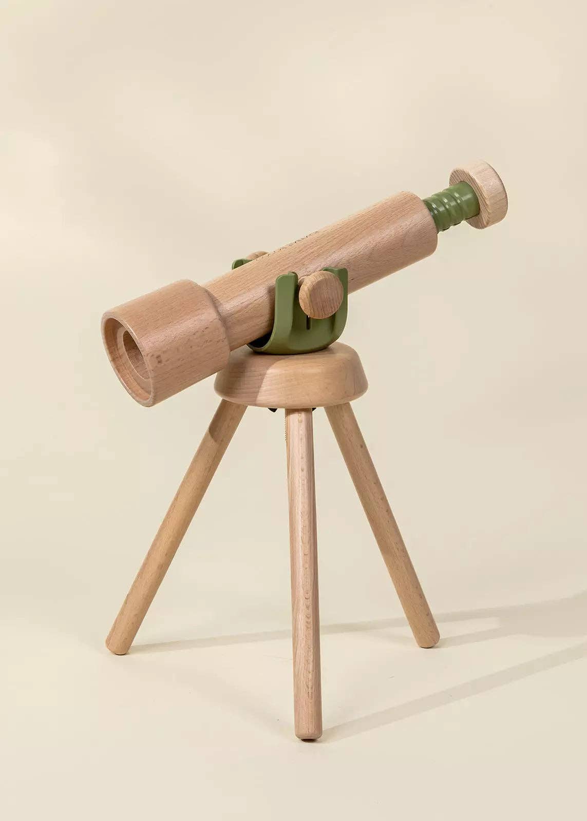Wooden telescope with green accents on a beige background