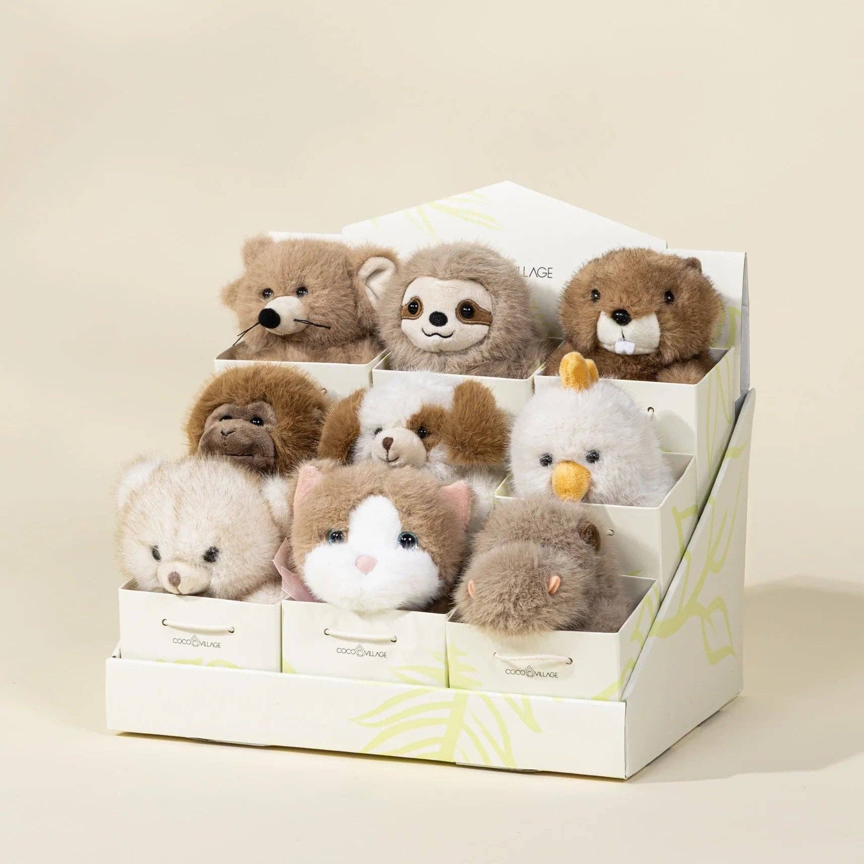 Set of small stuffed animals in a display box on a beige background