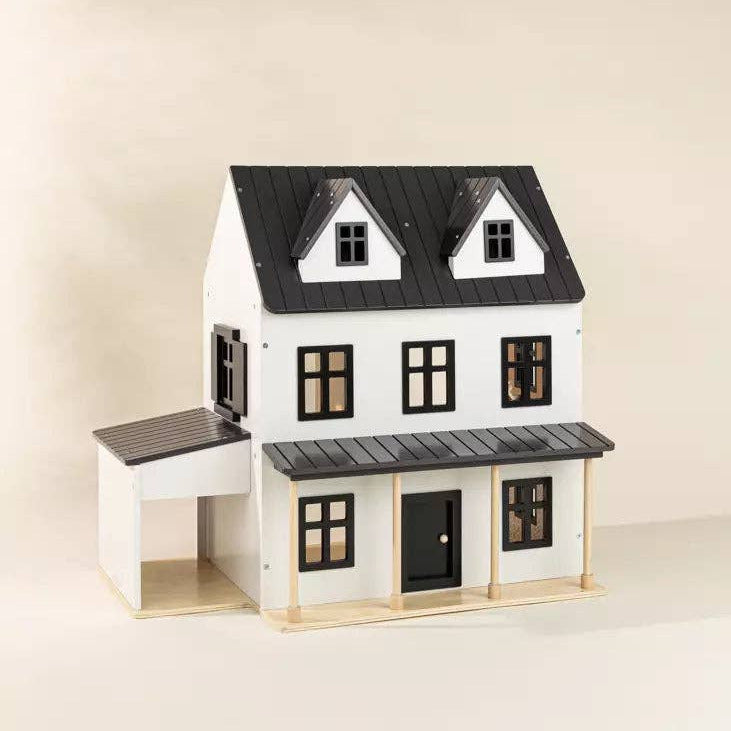 Model of a two-story house with black roof and windows on a beige background