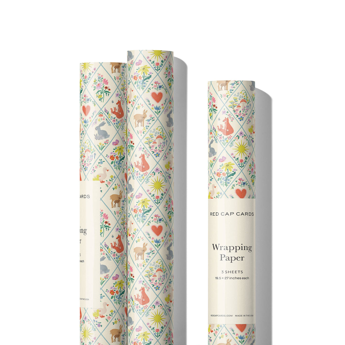 Three rolls of patterned wrapping paper with animal and nature designs on a white background.