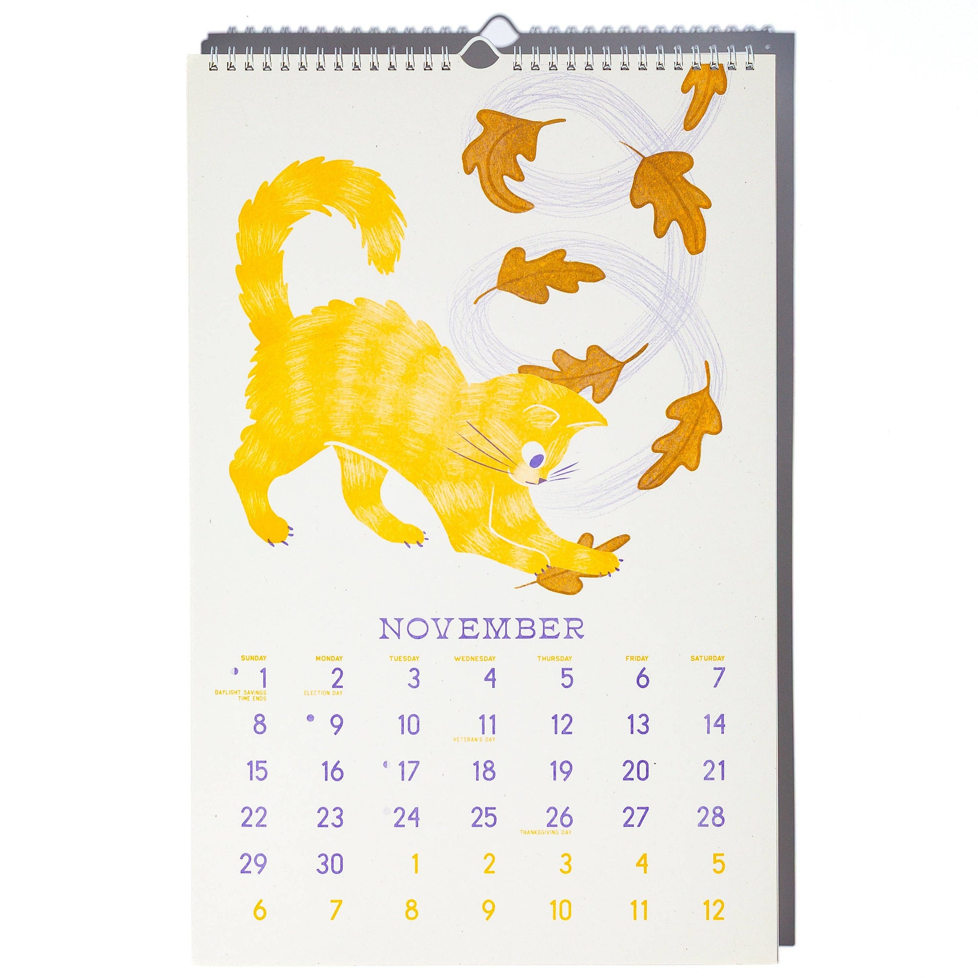 Calendar with a yellow cat illustration and falling leaves on a white background