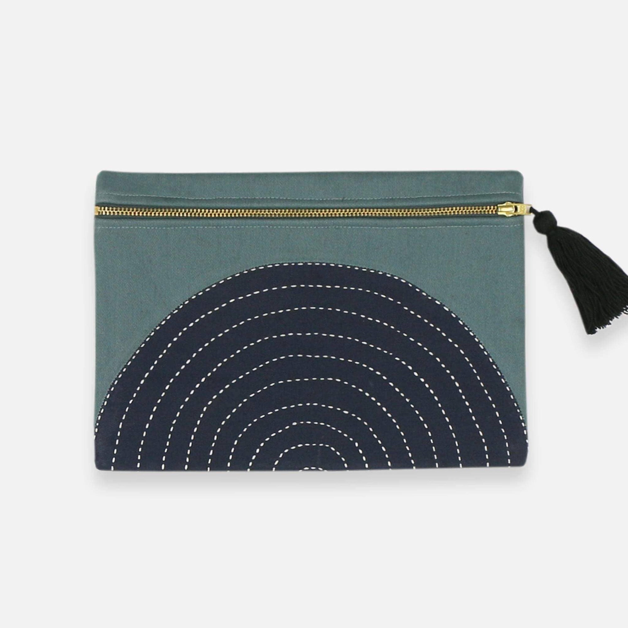 Green pouch with black circular pattern and tassel on a white background