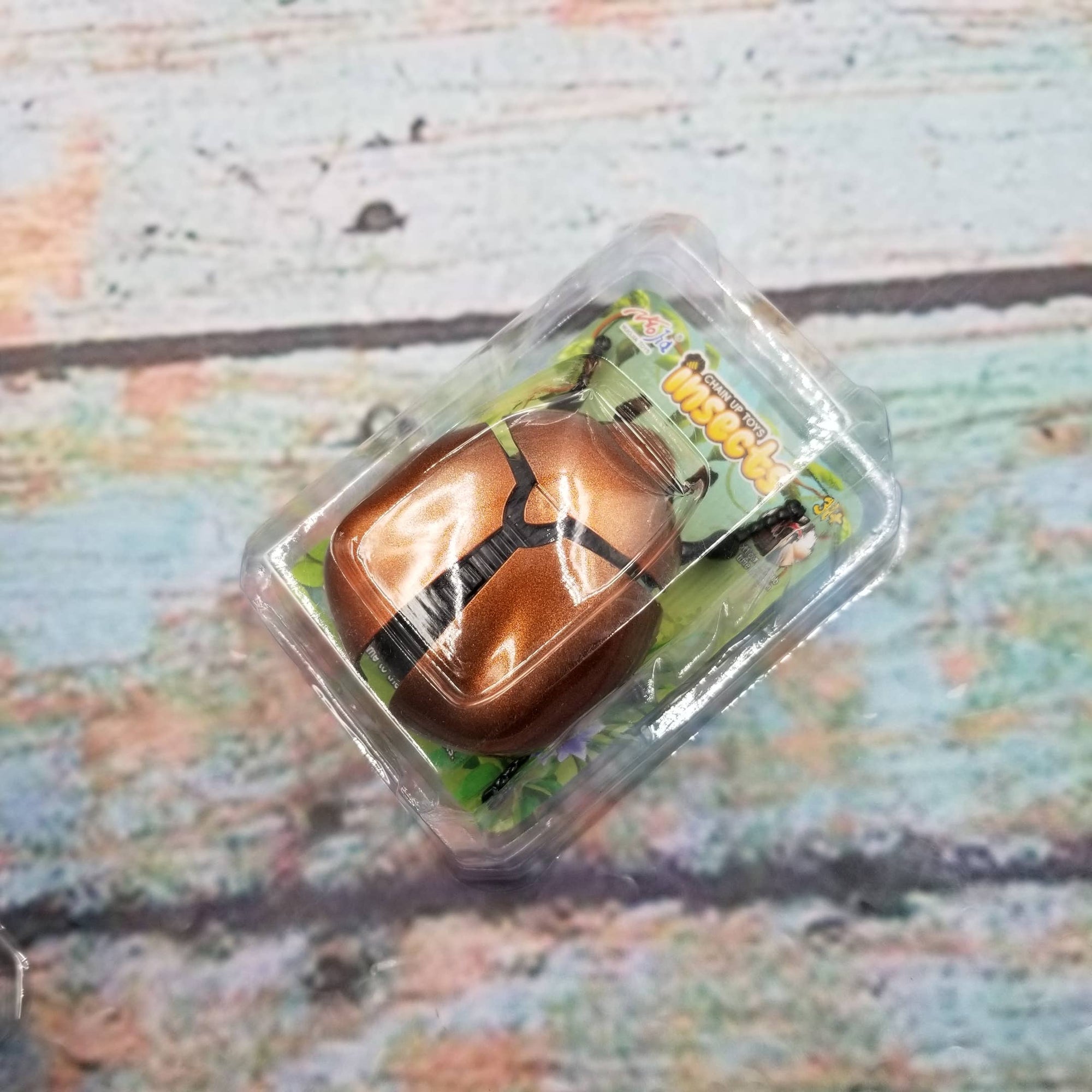 Small brown toy horse in clear packaging on a textured surface