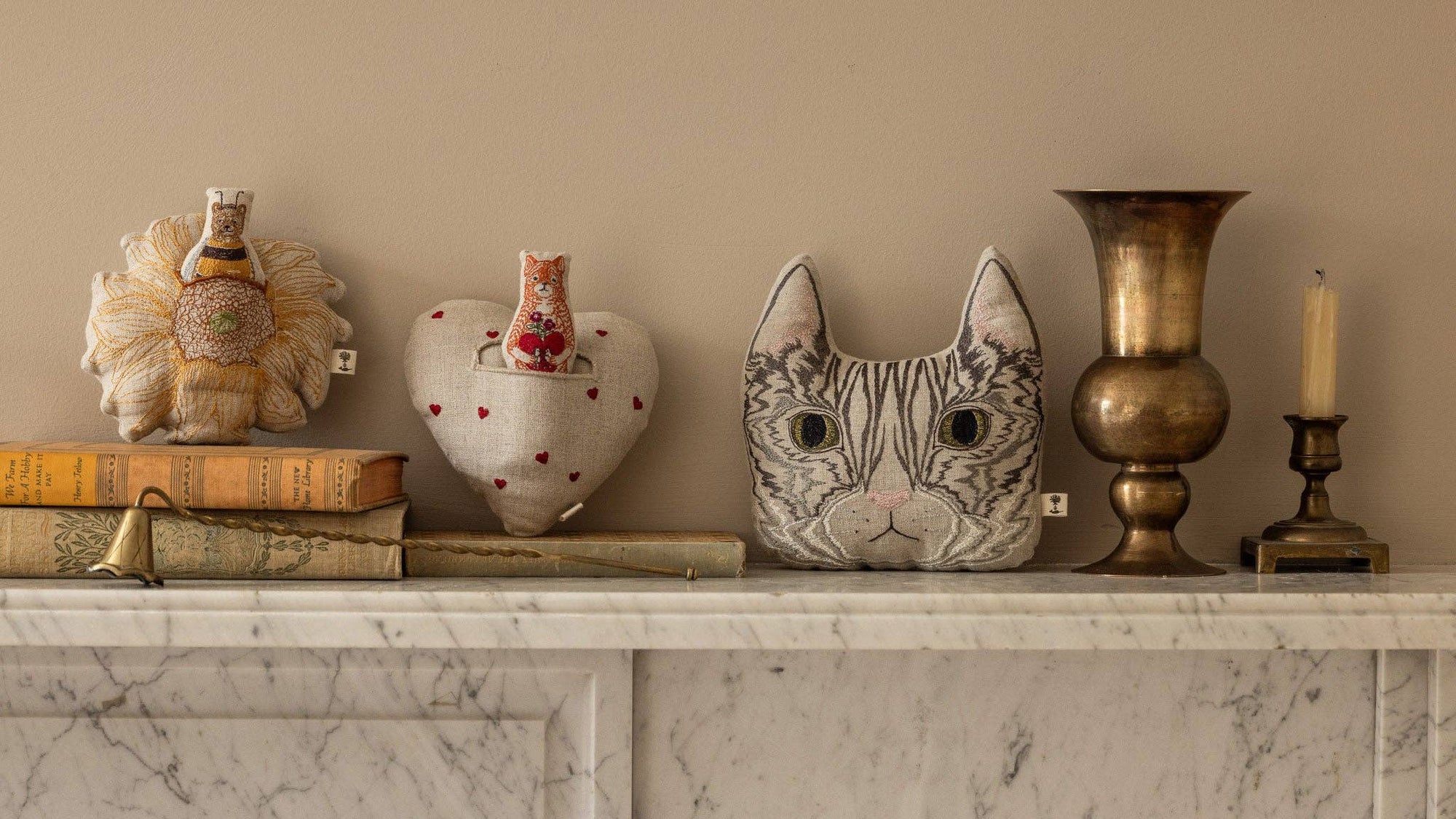 Decorative items including a cat-shaped vase, heart-shaped object, and books on a marble surface.