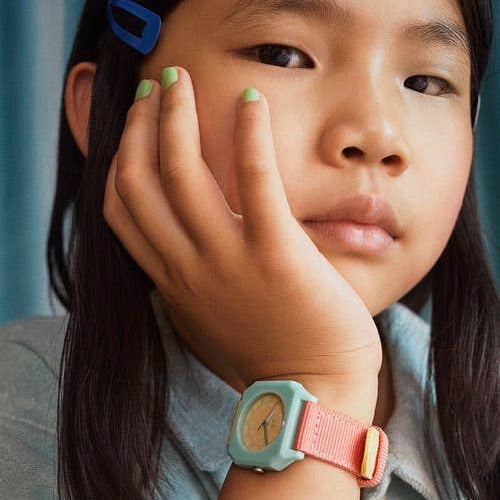 Young girl wearing a colorful watch with a blue background