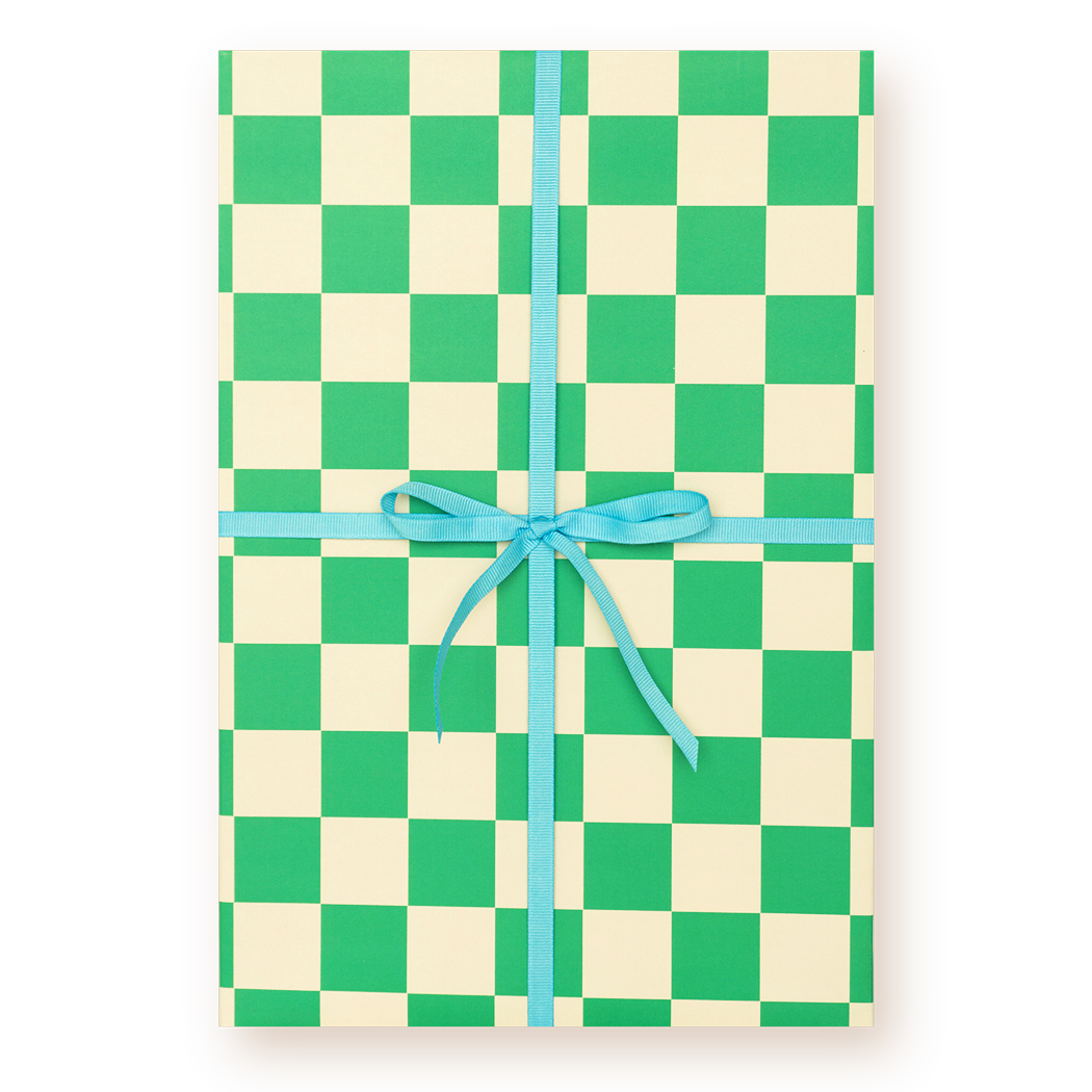 Checkered paper with green and beige squares tied with a blue ribbon on a white background