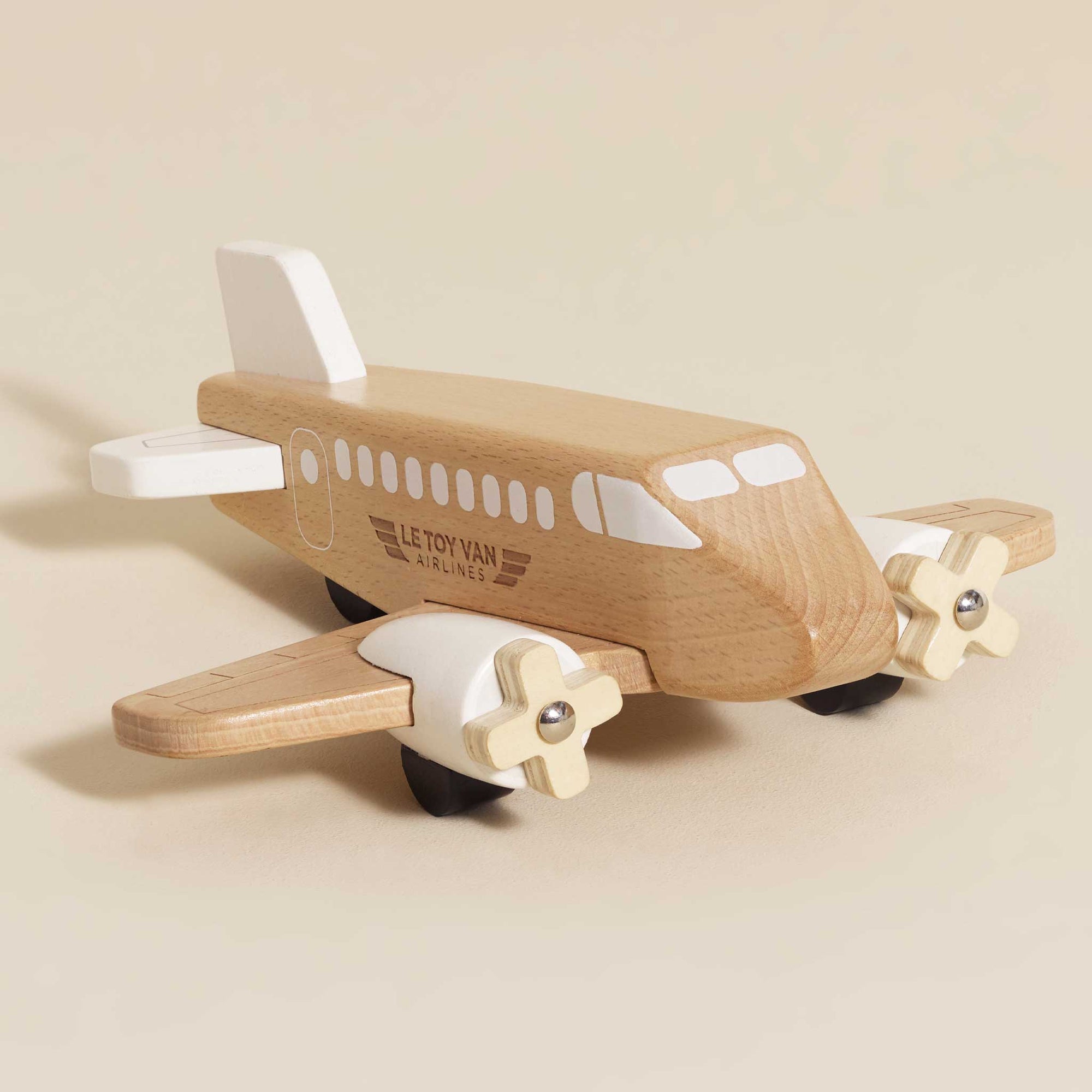 Wooden toy airplane with propellers on a beige background