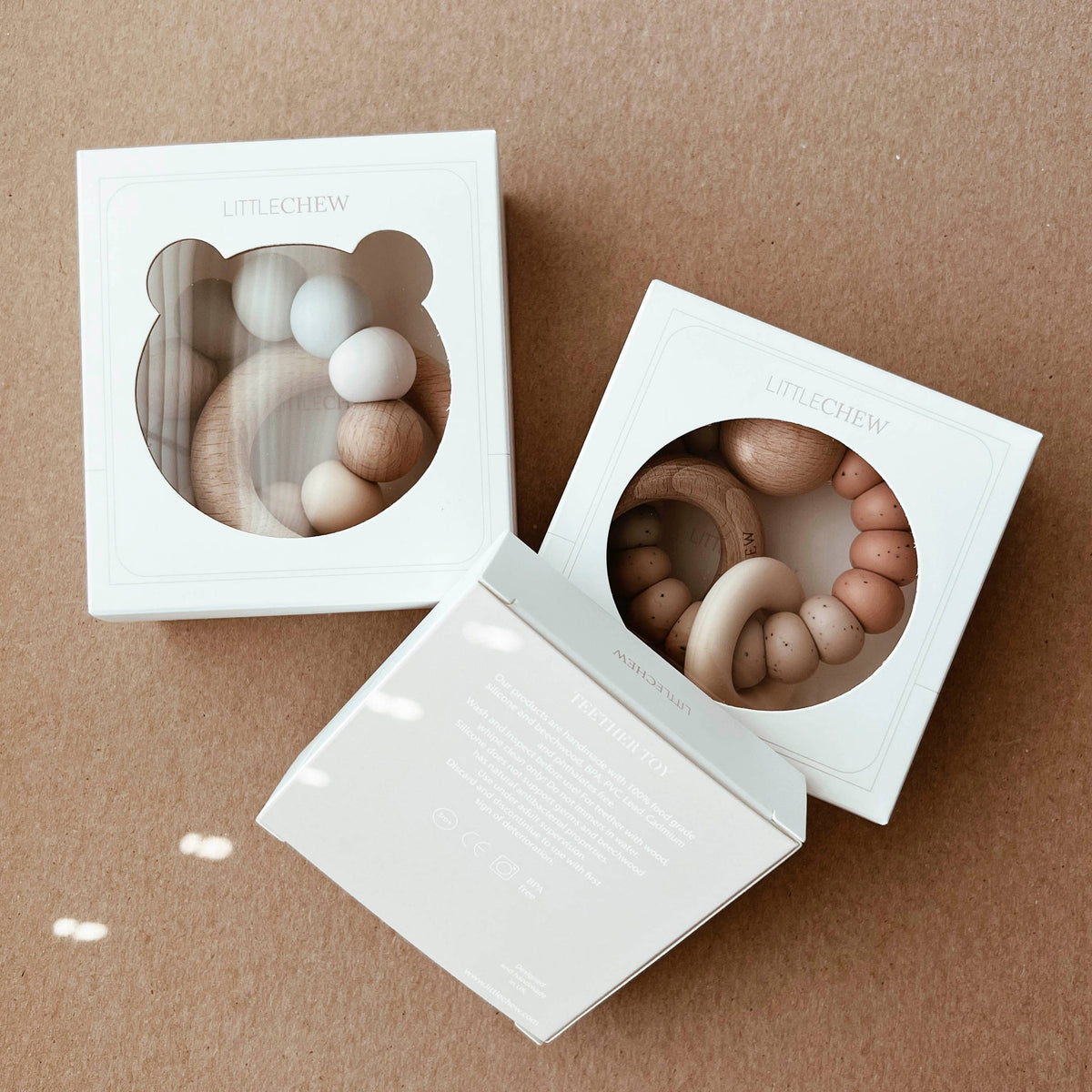 Two teethers in white boxes on a brown background