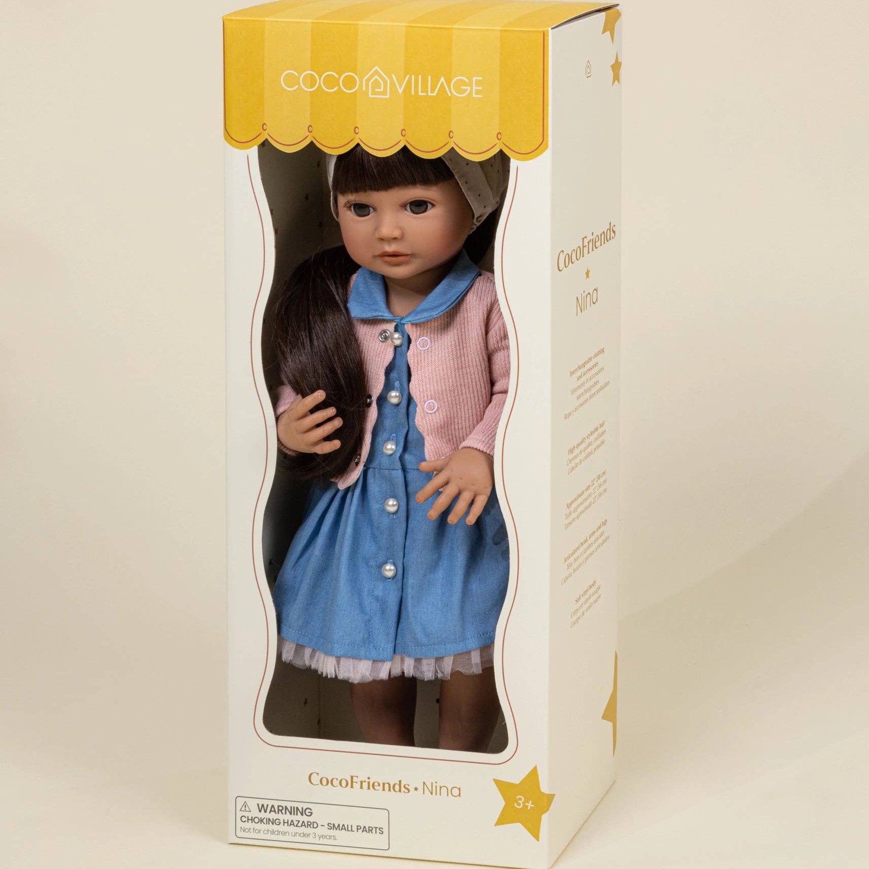 Coco Village doll in a box on a beige background