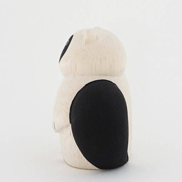 White plush toy with black accents on a light gray background