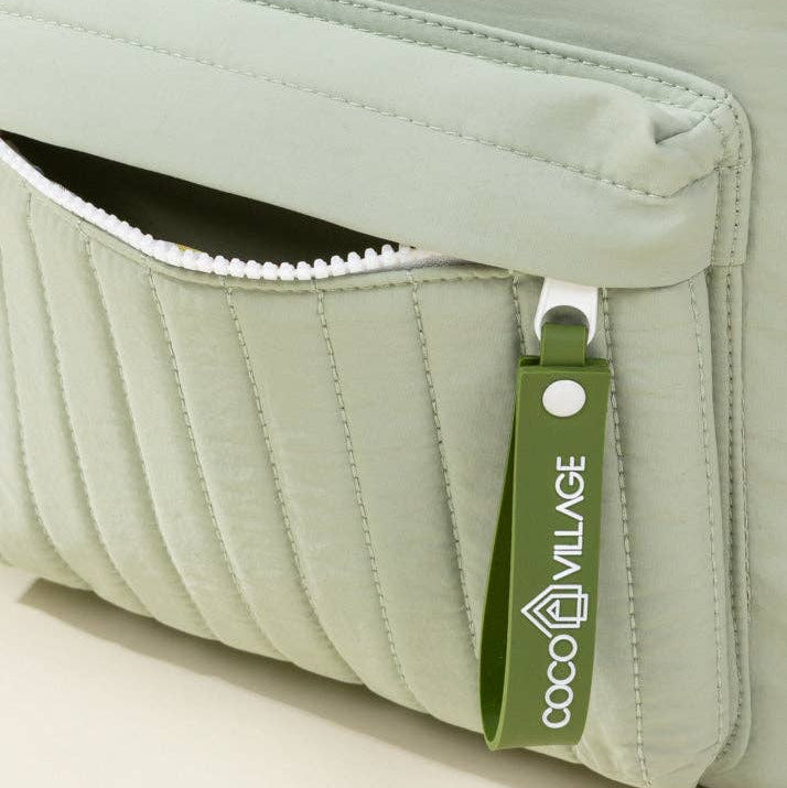Green quilted pouch with a visible brand logo on a neutral background