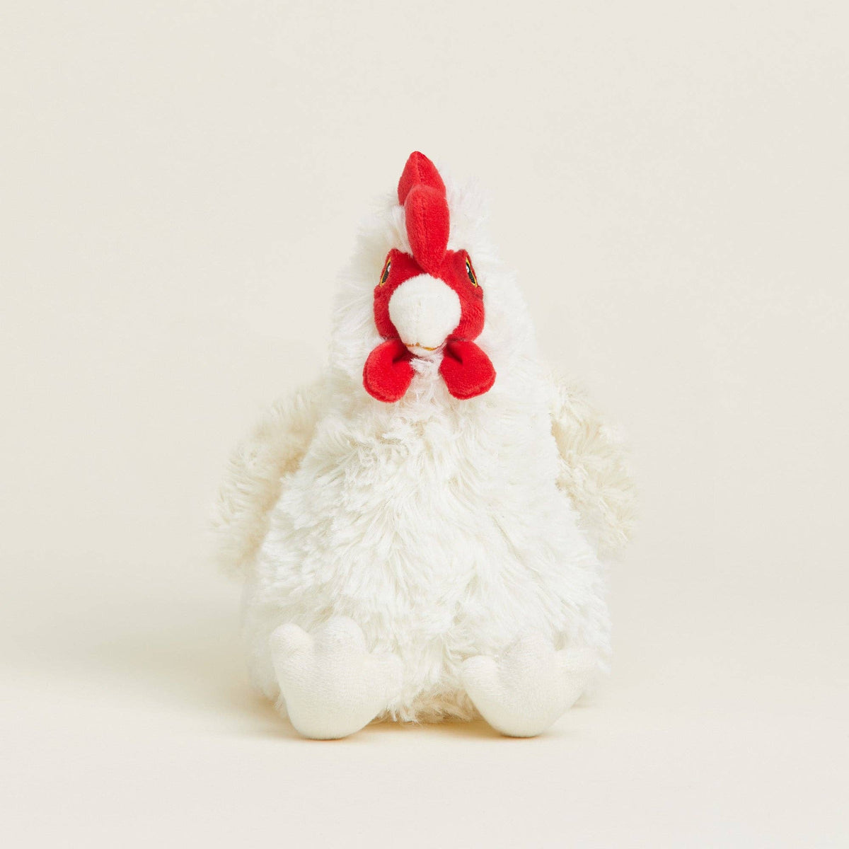 White plush toy with red accents on a light beige background