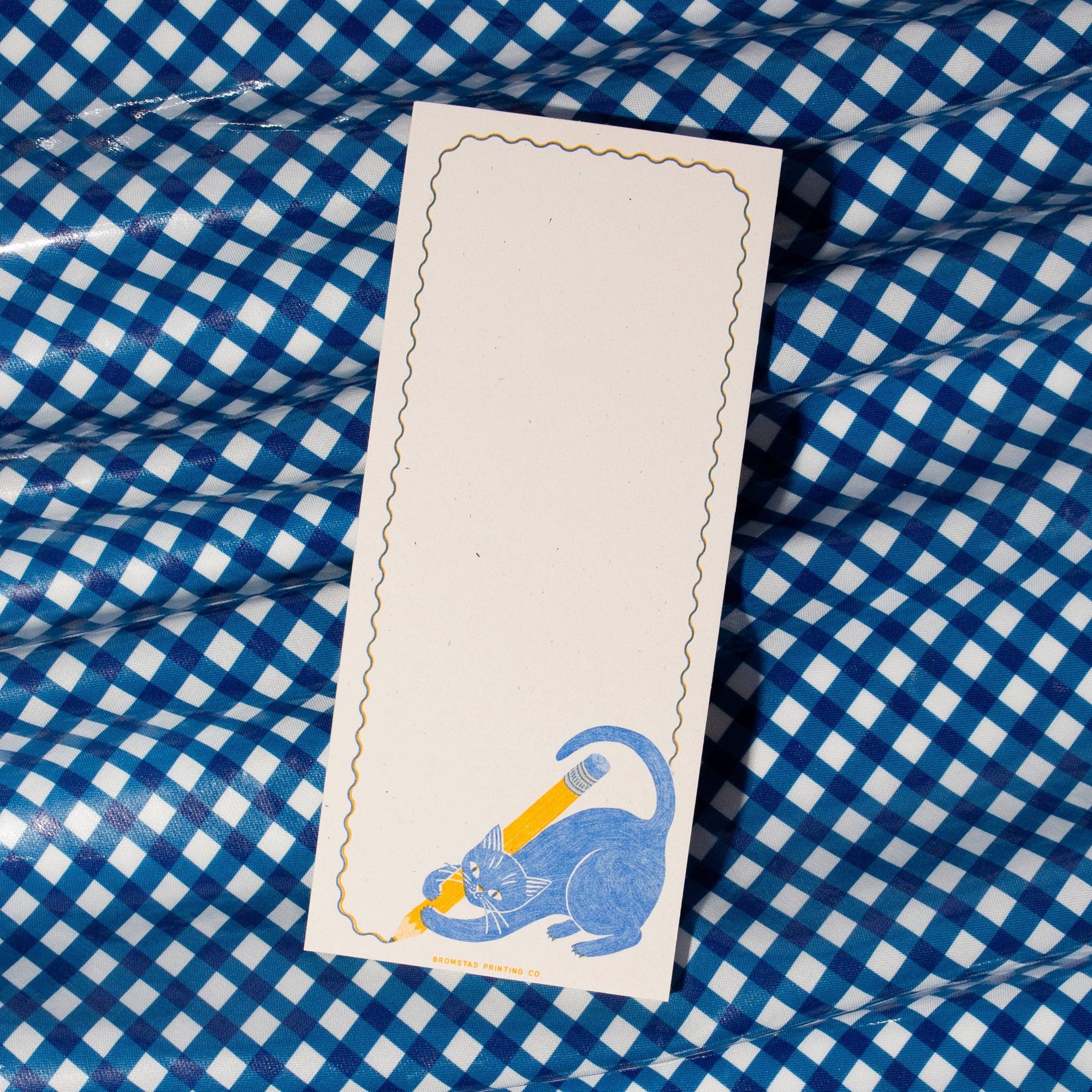 Bookmark with a blue cat design on a blue and white checkered fabric background