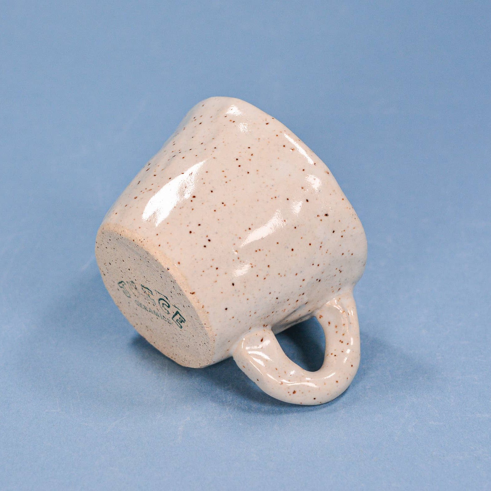 Speckled ceramic mug on a blue background