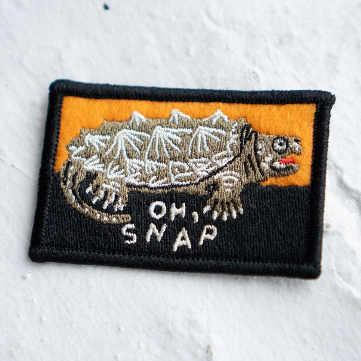 Embroidered patch with a turtle design and 'Oh, Snap' text on a white background