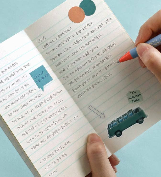 Handwritten notes in a notebook with colorful stickers and a pen on a light blue background