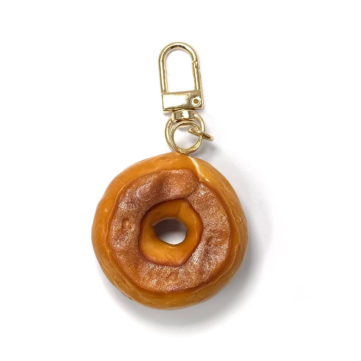 bagel-shaped keychain with gold clasp on a white background